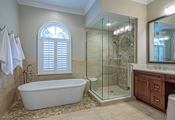 Modern bathroom design with a freestanding bathtub and custom cabinetry in Calabasas home renovation.