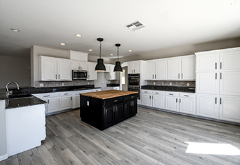 Elegant kitchen design in Northridge with white cabinetry, high-end appliances, and a stylish tile backsplash.